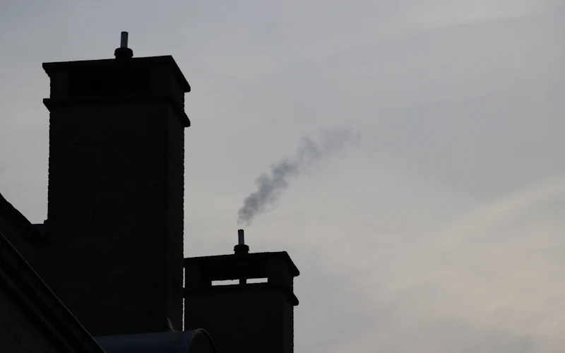 Canna fumaria che fuma su un tetto